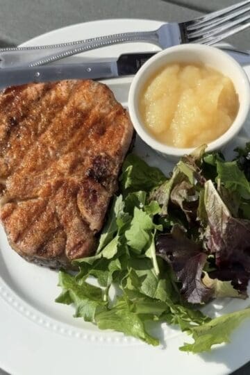 Juicy grilled pork chops served with summer side dishes for dinner.