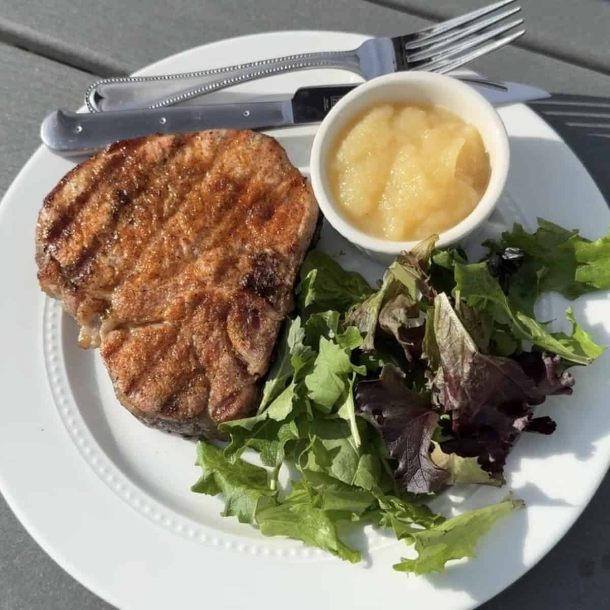 Juicy grilled pork chops served with summer side dishes for dinner.