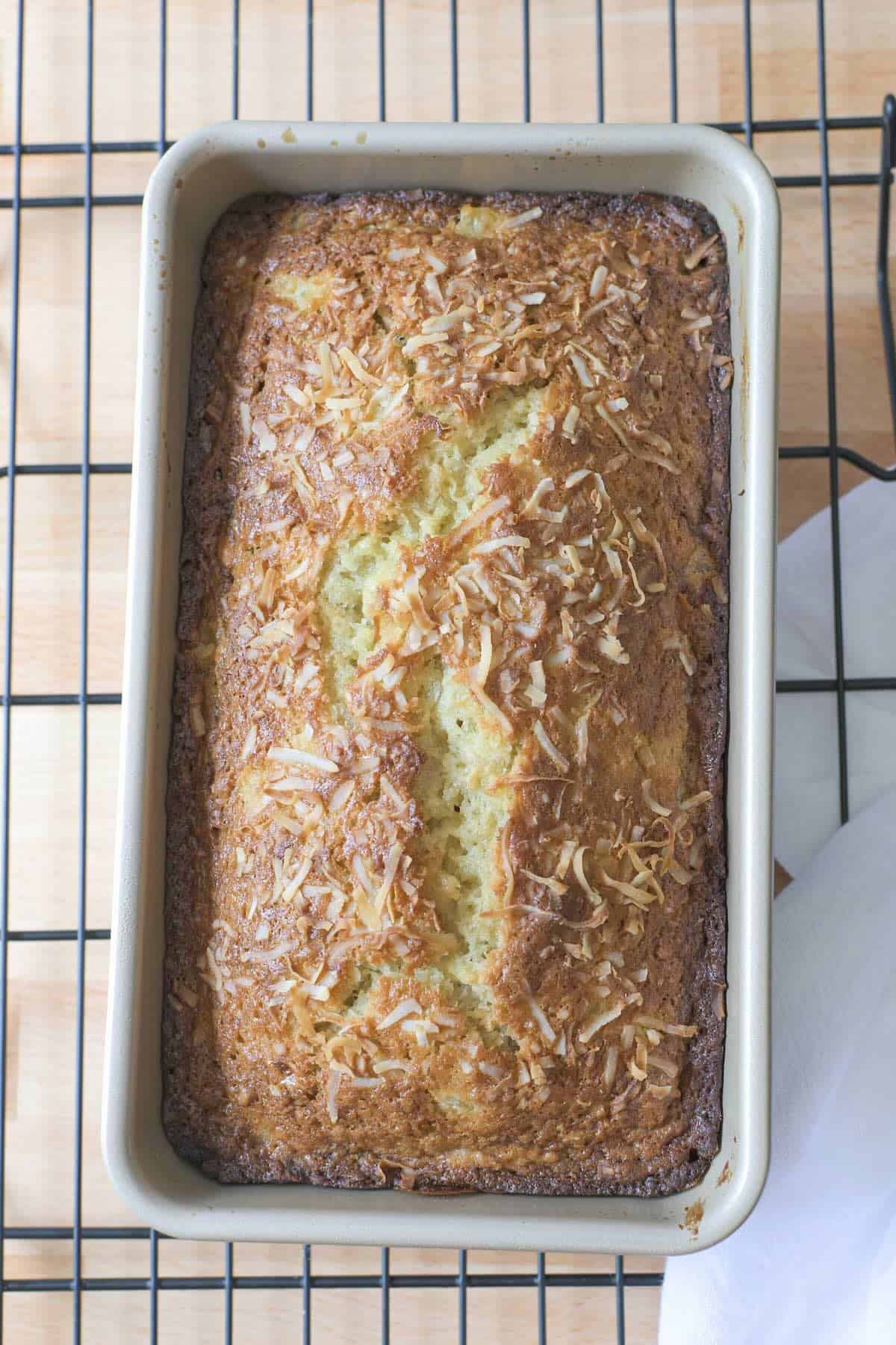 Freshly baked Hawaiian banana bread cooling in a loaf pan.