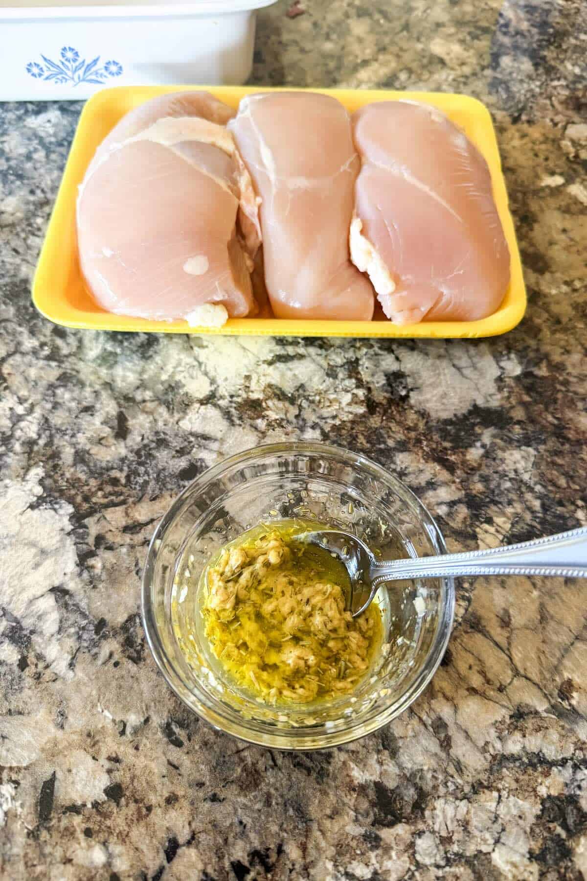 Ingredients for herb grilled chicken including chicken breasts, Dijon mustard, olive oil, garlic, rosemary, and oregano.