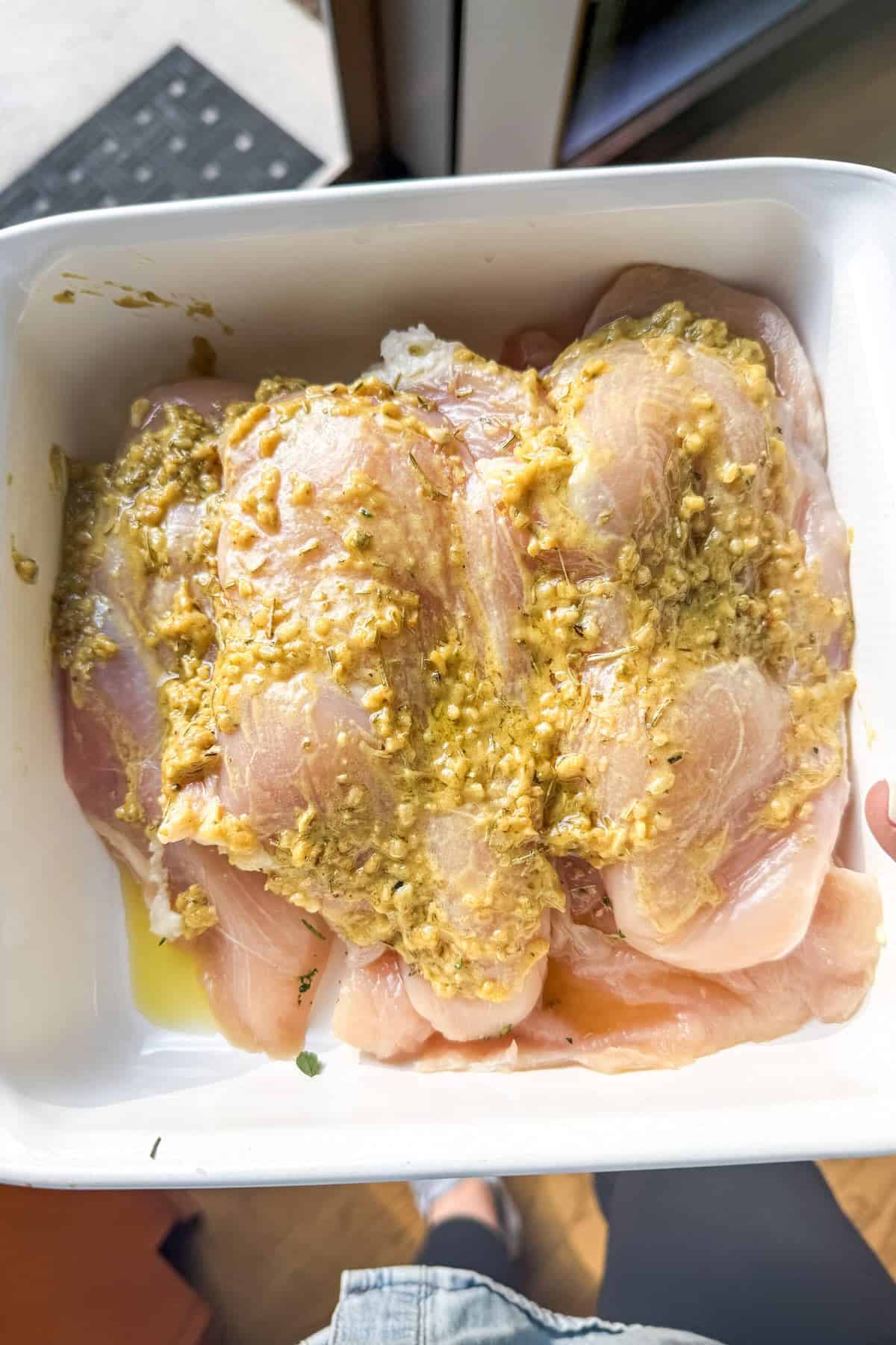 Chicken breasts marinating in a Dijon herb marinade before grilling.