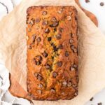 Moist chocolate chip banana bread on parchment paper.