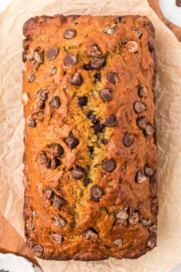 Moist chocolate chip banana bread on parchment paper.