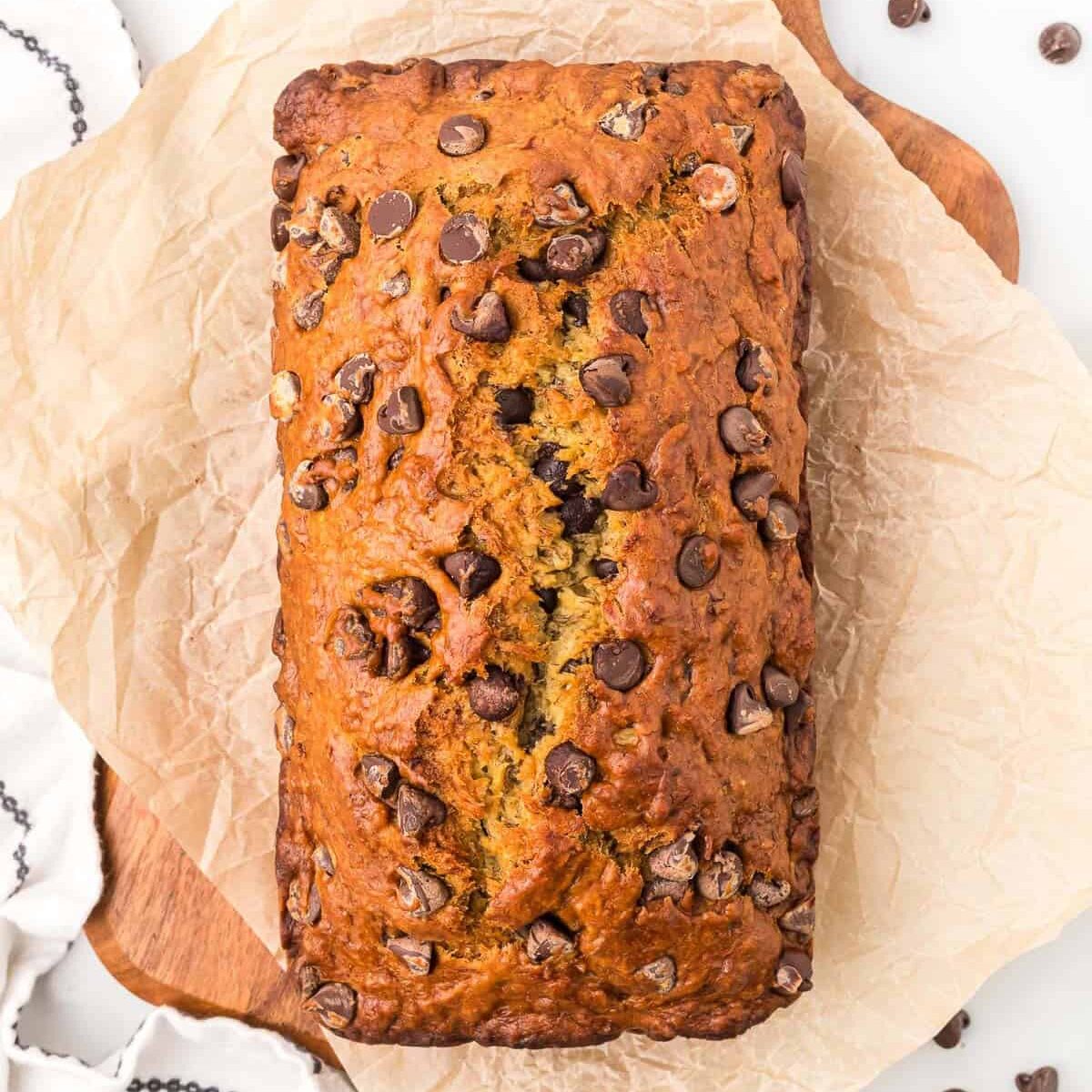 Moist chocolate chip banana bread on parchment paper.