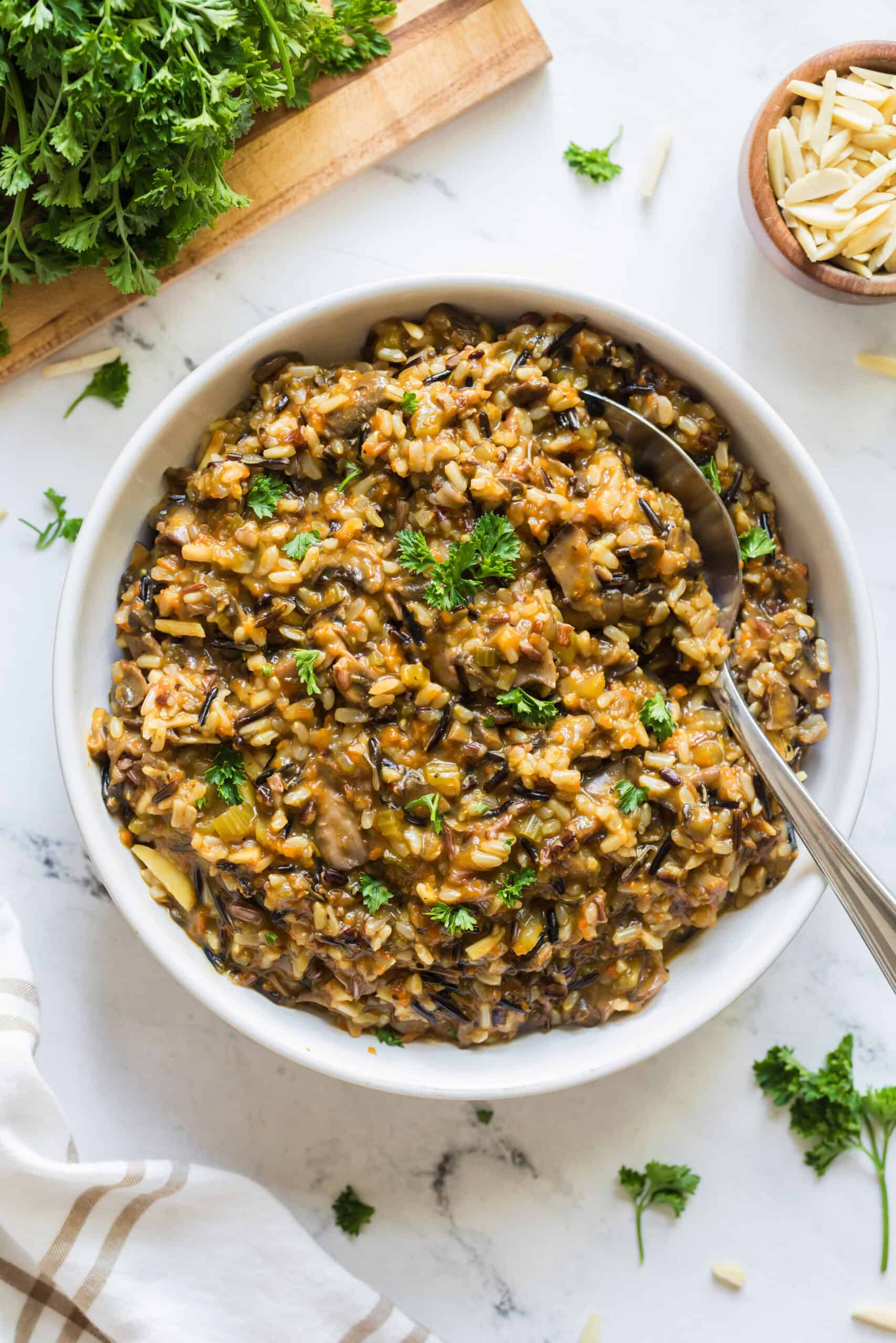 Wild rice pilaf served in a bowl with fresh parsley and toasted almonds.