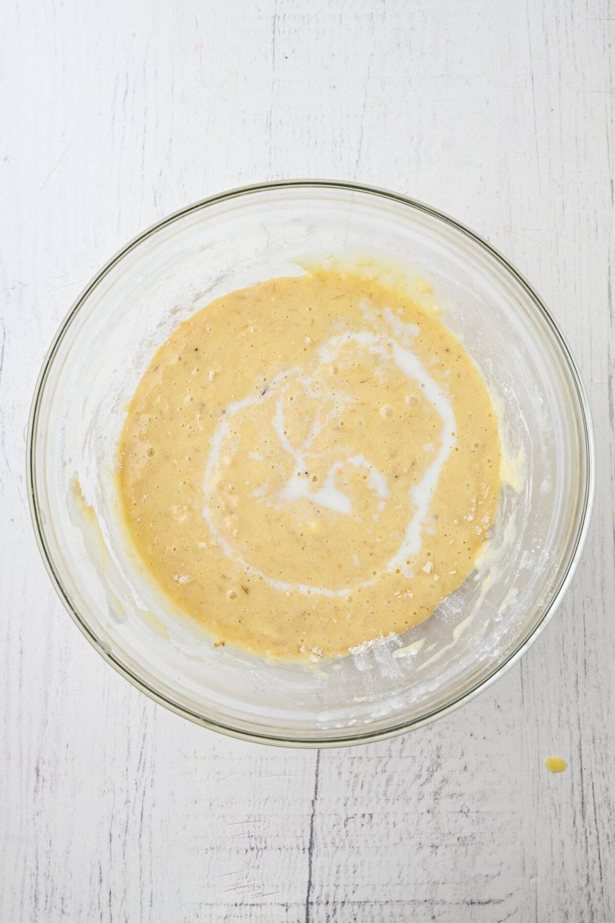Wet and dry muffin batter ingredients combined in a mixing bowl.