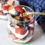 Red white and blue cheesecake parfaits made with strawberries, blueberries, and cheesecake filling.