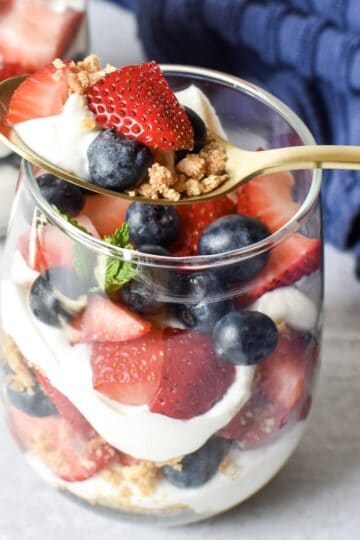 Red white and blue cheesecake parfaits made with strawberries, blueberries, and cheesecake filling.