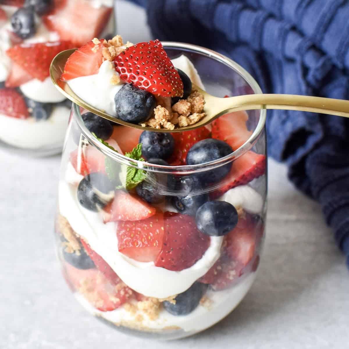 Red white and blue cheesecake parfaits made with strawberries, blueberries, and cheesecake filling.