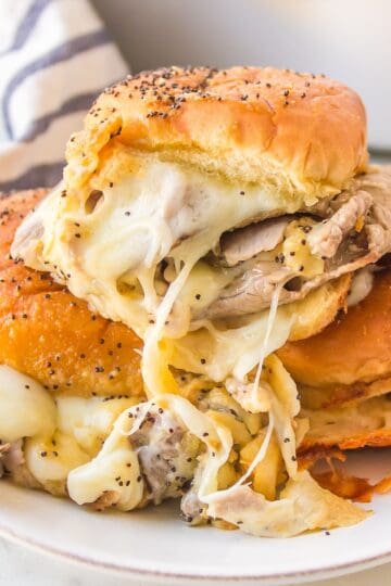 Roast beef sliders on Hawaiian rolls with provolone cheese and horseradish sauce.
