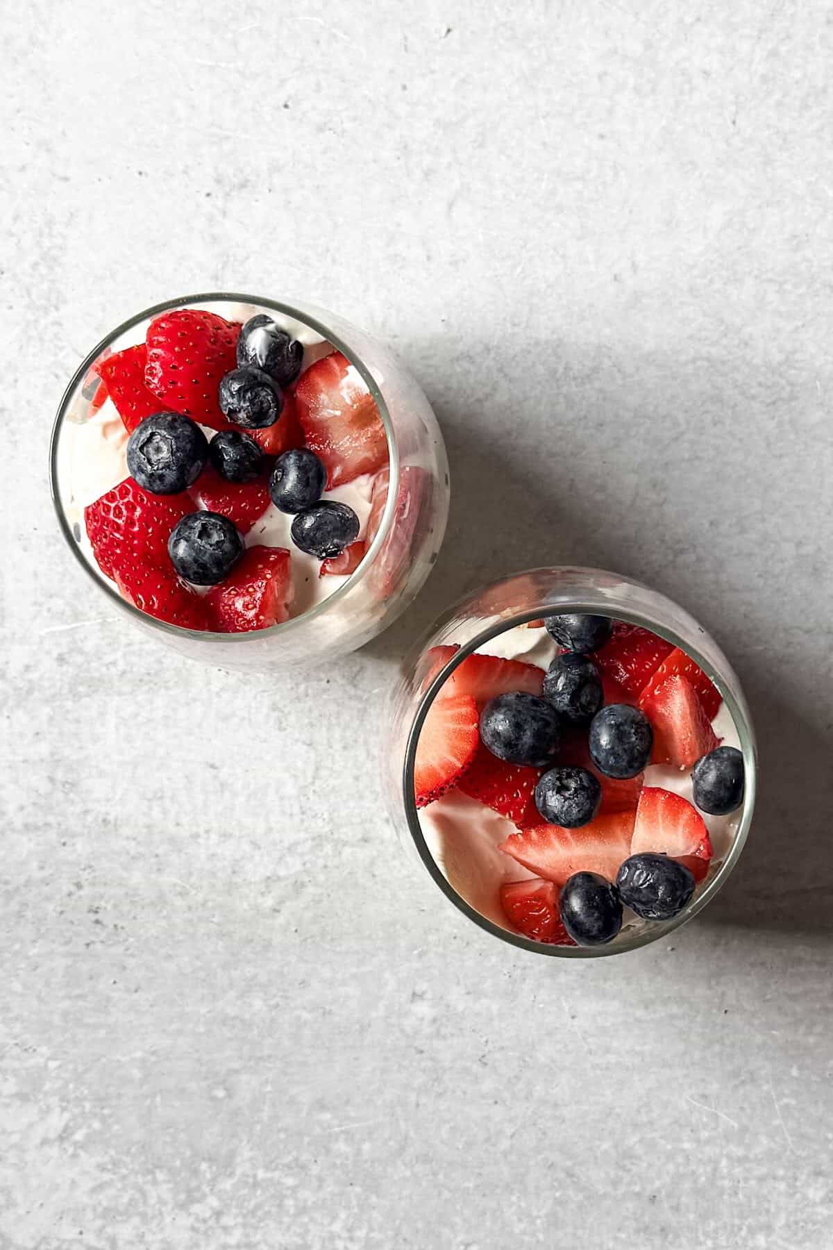 Fresh strawberries and blueberries layered into a no bake cheesecake parfait.