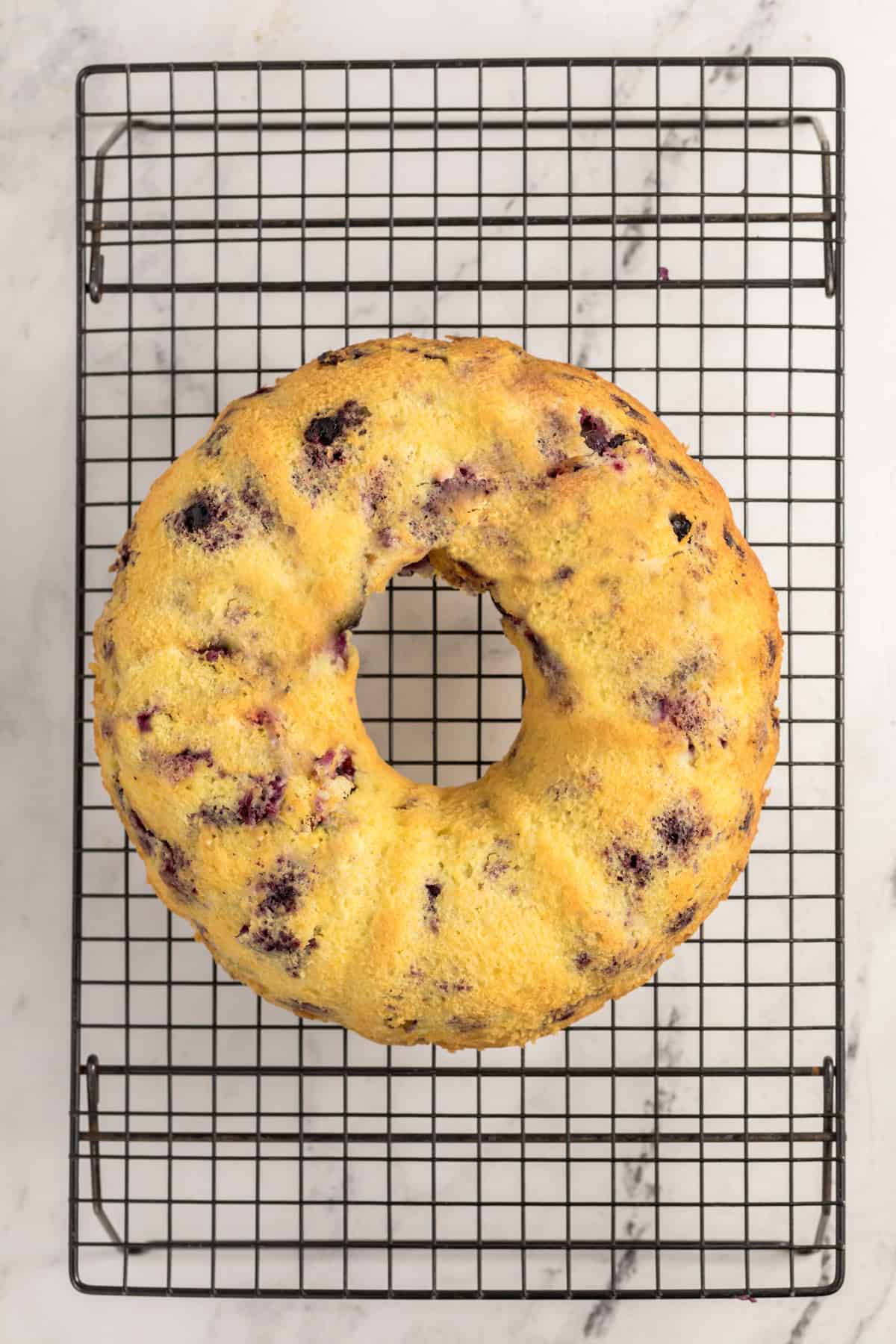 Lemon blueberry bundt cake inverted onto a serving plate after baking.