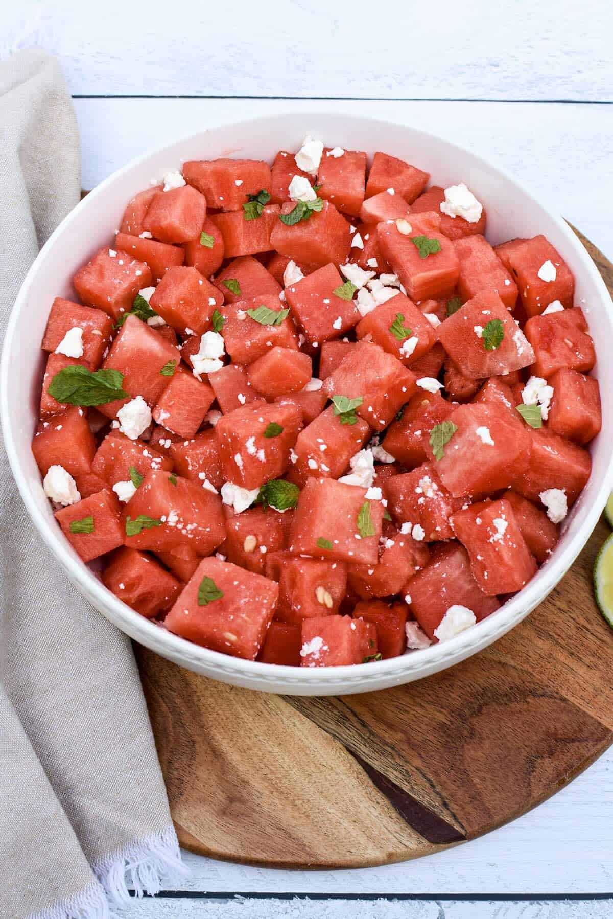 Adding feta cheese and mint to watermelon salad.