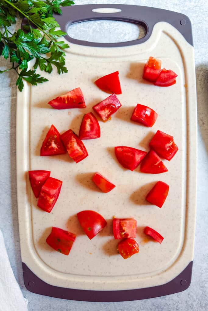 Fresh tomatoes cut into bite-sized pieces for cucumber tomato salad.