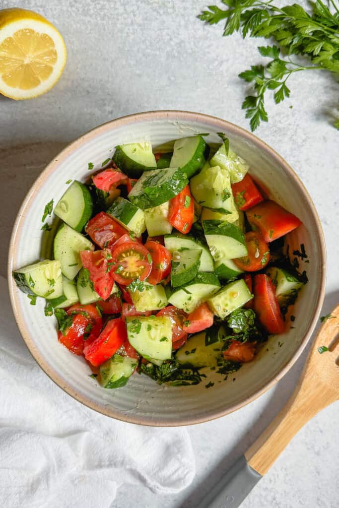 Tossed cucumber tomato salad with a simple lemon and olive oil dressing.