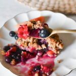 A bite of blueberry peach crisp with a crunchy oat topping.
