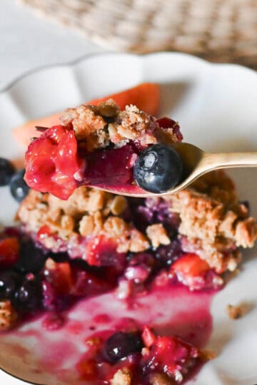 A bite of blueberry peach crisp with a crunchy oat topping.