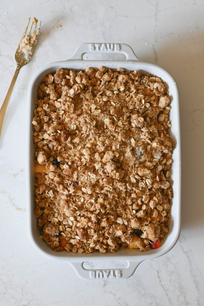 Blueberry peach cobbler topped with an oatmeal and sugar topping for a crisp.