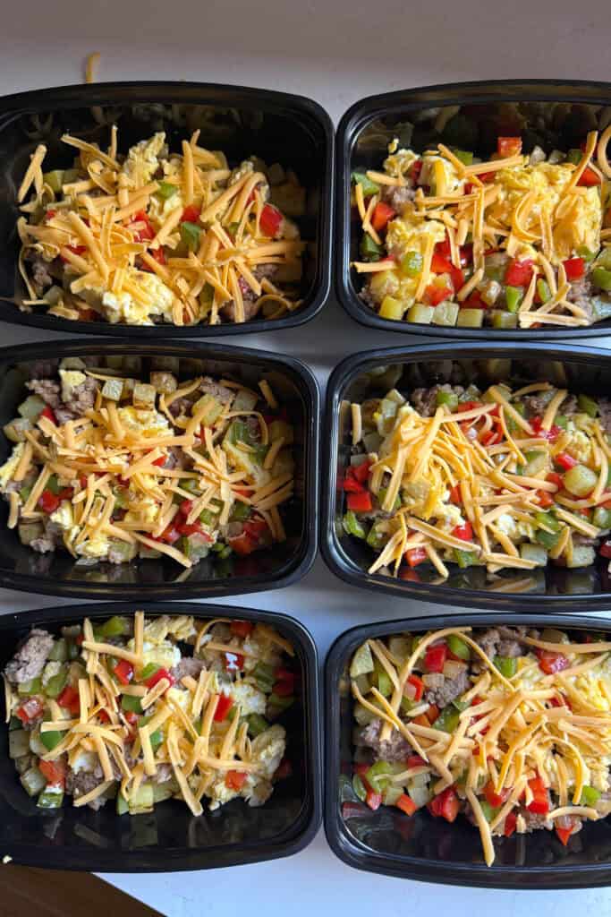 Two rows of made ahead breakfasts with eggs, sausage, potatoes and cheese.