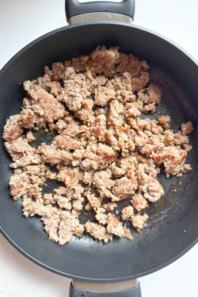 Cooked pork sausage in a skillet.