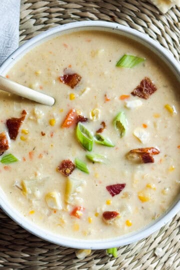 A bowl of creamy corn chowder with bacon and potatoes.