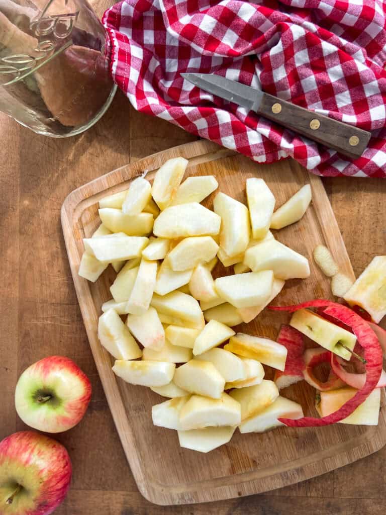 Peeled and sliced apples on a cutting board.