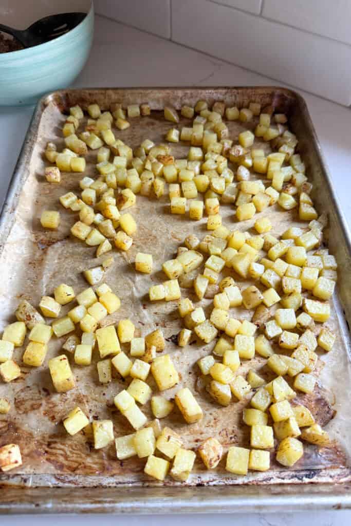 A sheet pan of diced roasted potatoes.