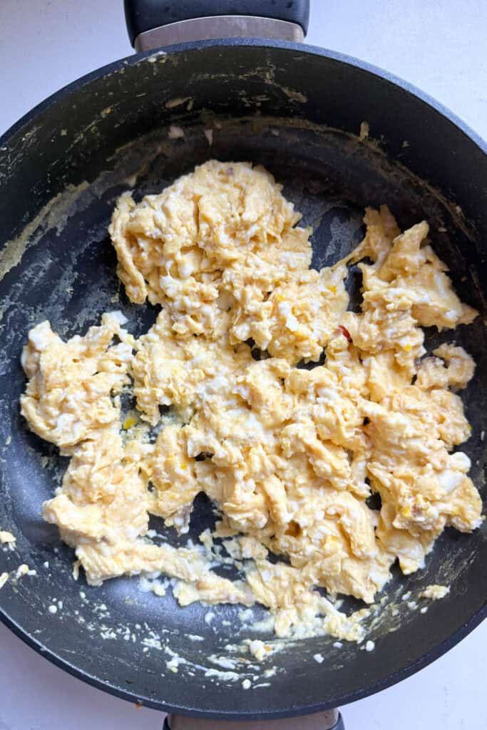 A batch of scrambled eggs in a skillet.