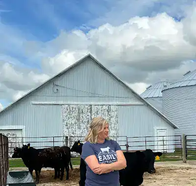 Deanne Frieders standing with cattle.
