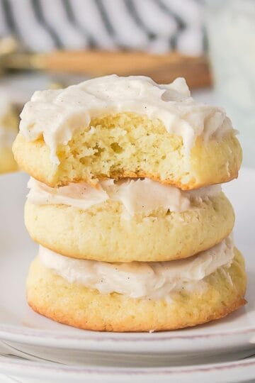 A stack of soft sour cream cookies with buttercream frosting.